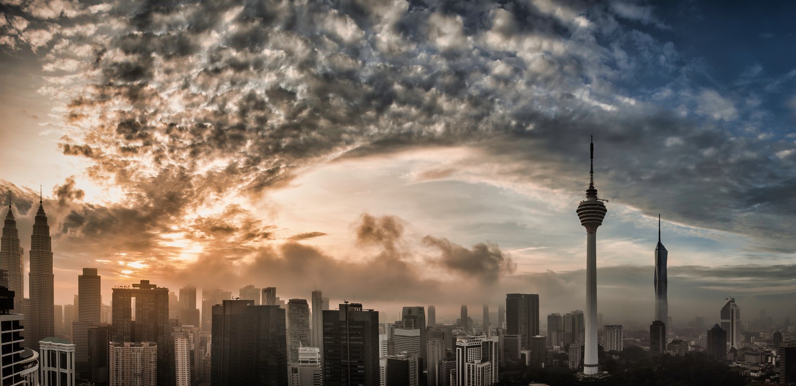 Kuala Lumpur skyline panorama at dawn, Petronas Towers, KL Tower and Merdeka 118 under a warm sunrise sky